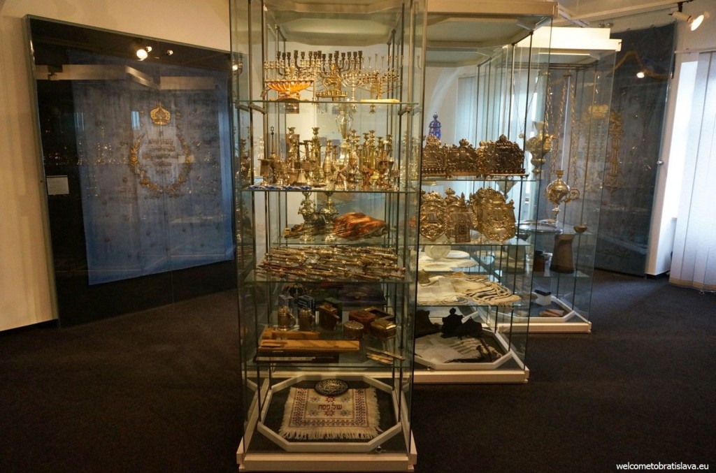 Metal candlesticks are displayed in glass showcases